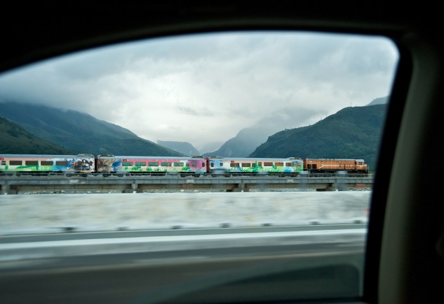 Formosa Express, a five-star tourist train, races sedans running alongside it on highway in Ji'an Township, Hualien County, Taiwan