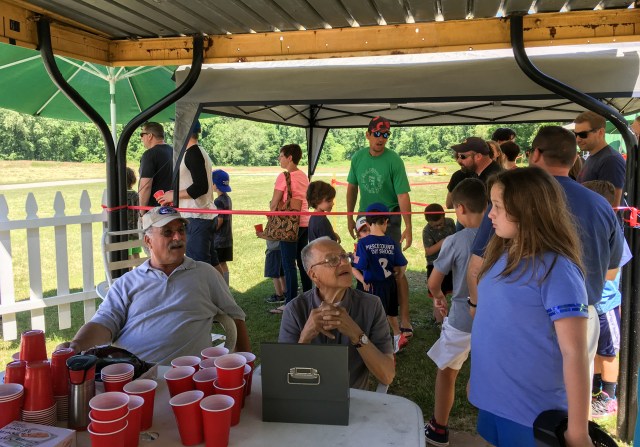 Visitors line up with cups of paintballs in hand
